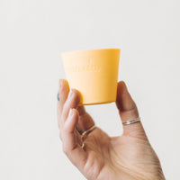 Hand holding a single yellow Silicone Dariole Mould