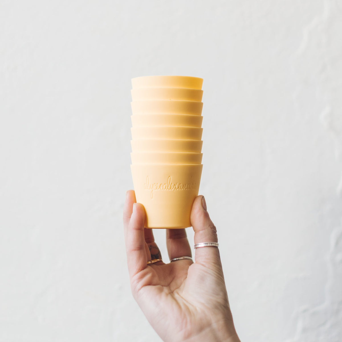 Hand holding a stack of yellow Silicone Dariole Moulds