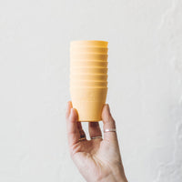 Hand holding a stack of yellow Silicone Dariole Moulds