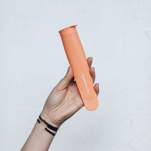 Hand holding a single orange Silicone Push Up Ice Cream Mould