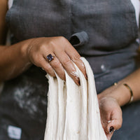 Hands stretching a length of sourdough dough to show its gluten development