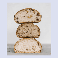Stack of three thick slices of sourdough loaf of bread showing the open crumb