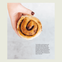 Hand holding a cinnamon scroll made with sourdough, from Simple Sourdough