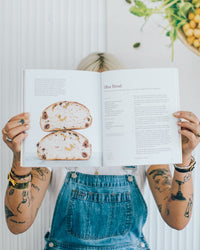 Ellen holding Simple Sourdough open at a recipe spread