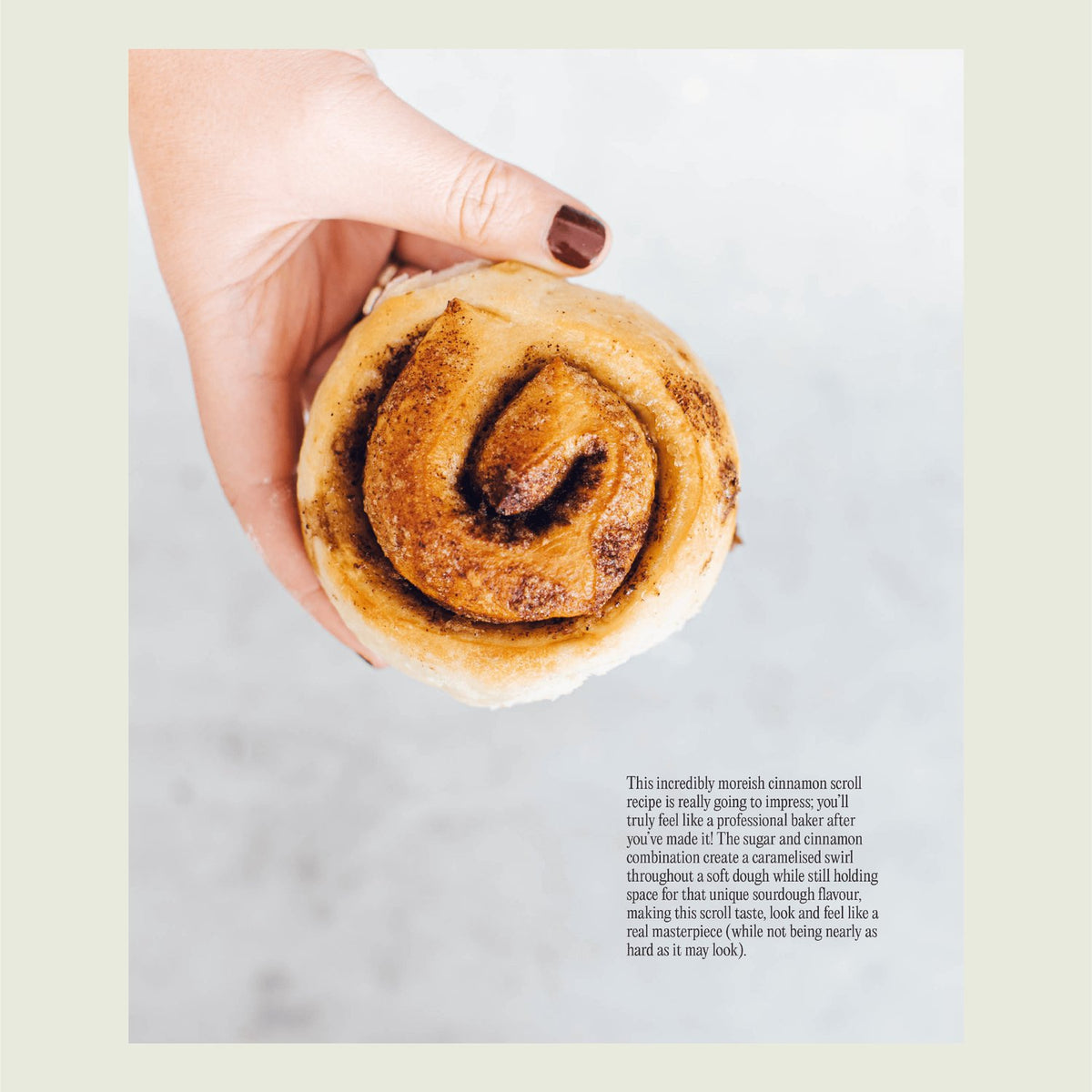Hand holding a cinnamon scroll made with sourdough, from Simple Sourdough