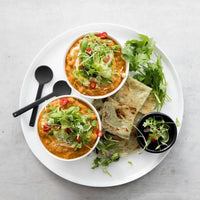 Bowls of curry served with flatbread, salad and yoghurt, from Slow Cooker Recipes with Thermomix-Prep Options