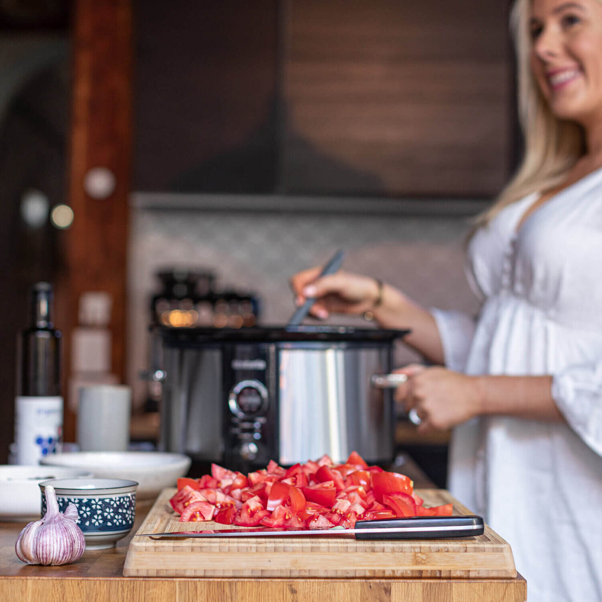 Alyce prepping ingredients at a bench beside her slow cooker