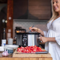 Alyce prepping ingredients at a bench beside her slow cooker