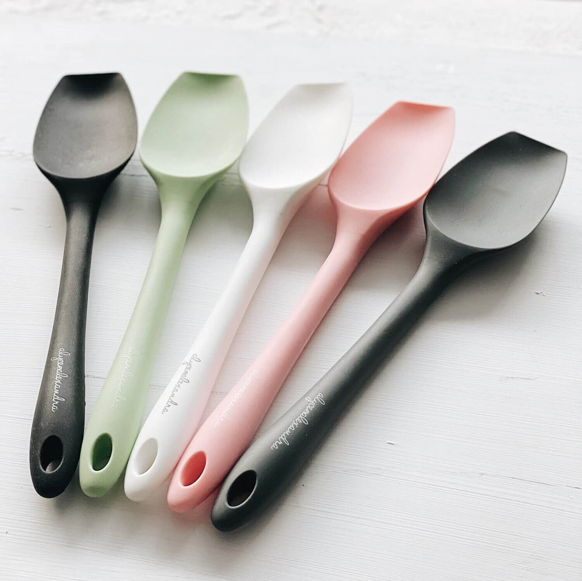 Five Slow Cooker Spatulas laid side by side in charcoal, sage, white, pink and black