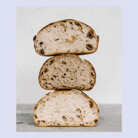 Stack of three thick slices of sourdough loaf of bread showing the open crumb