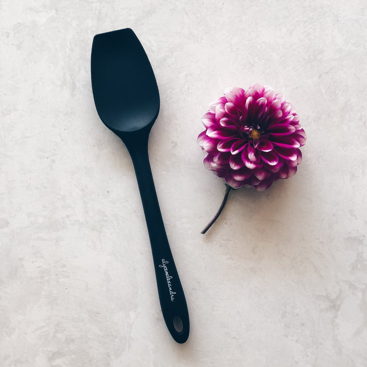 Charcoal Sourdough Spatula laid beside a purple dahlia