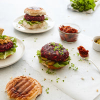 Beetroot burgers with salad and relish on plates, made using the Starter Kit