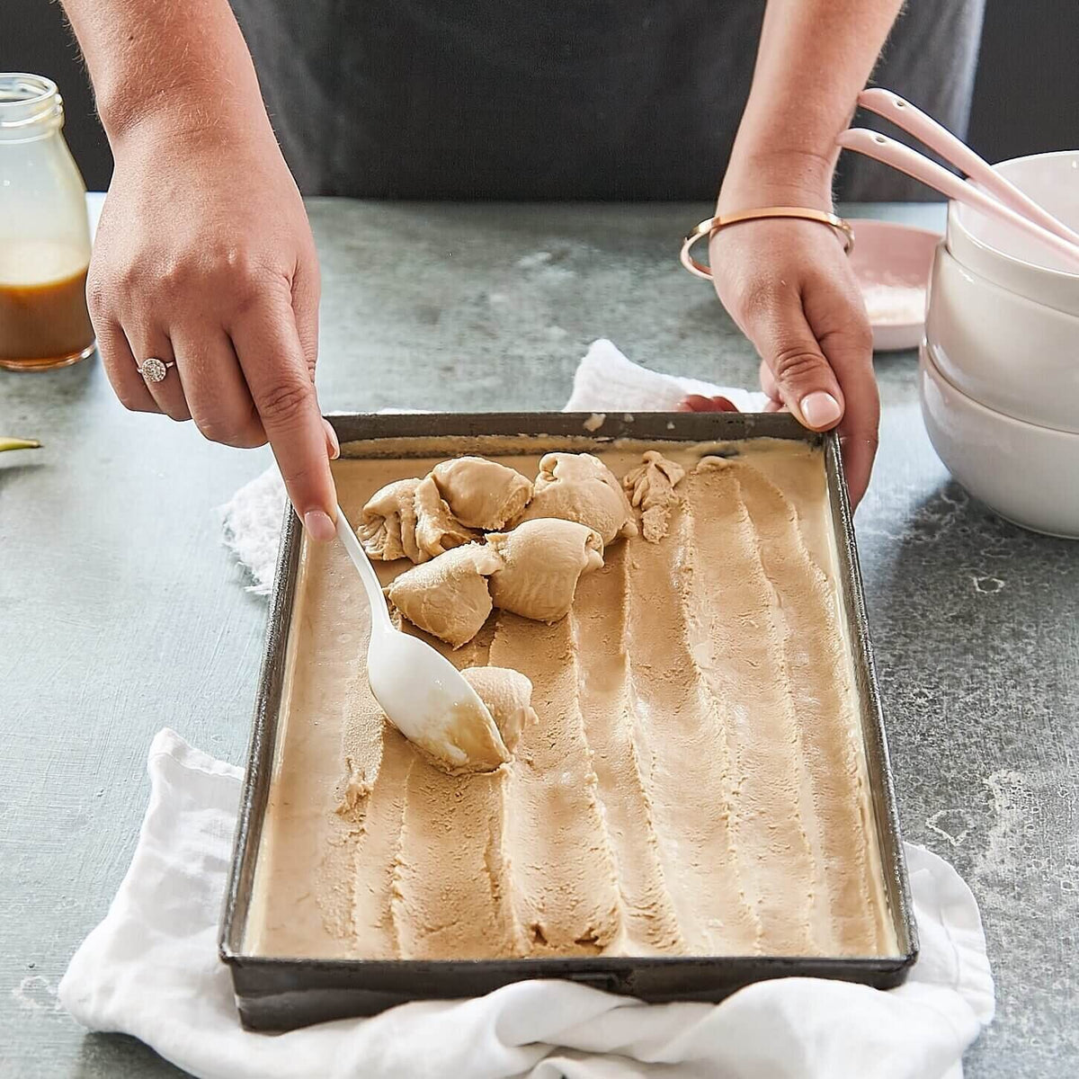 Hands lifting shaped dough from a tray, made using the Starter Kit