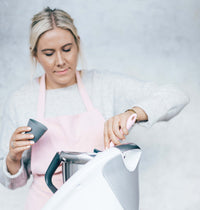 Alyce lifting the lid from her Thermomix in the kitchen
