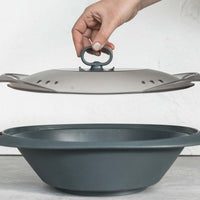Hand gripping the Suction Handle to lift the Varoma lid clear of the tray