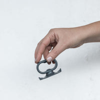 Close-up of the Suction Handle held between finger and thumb, showing its suction base