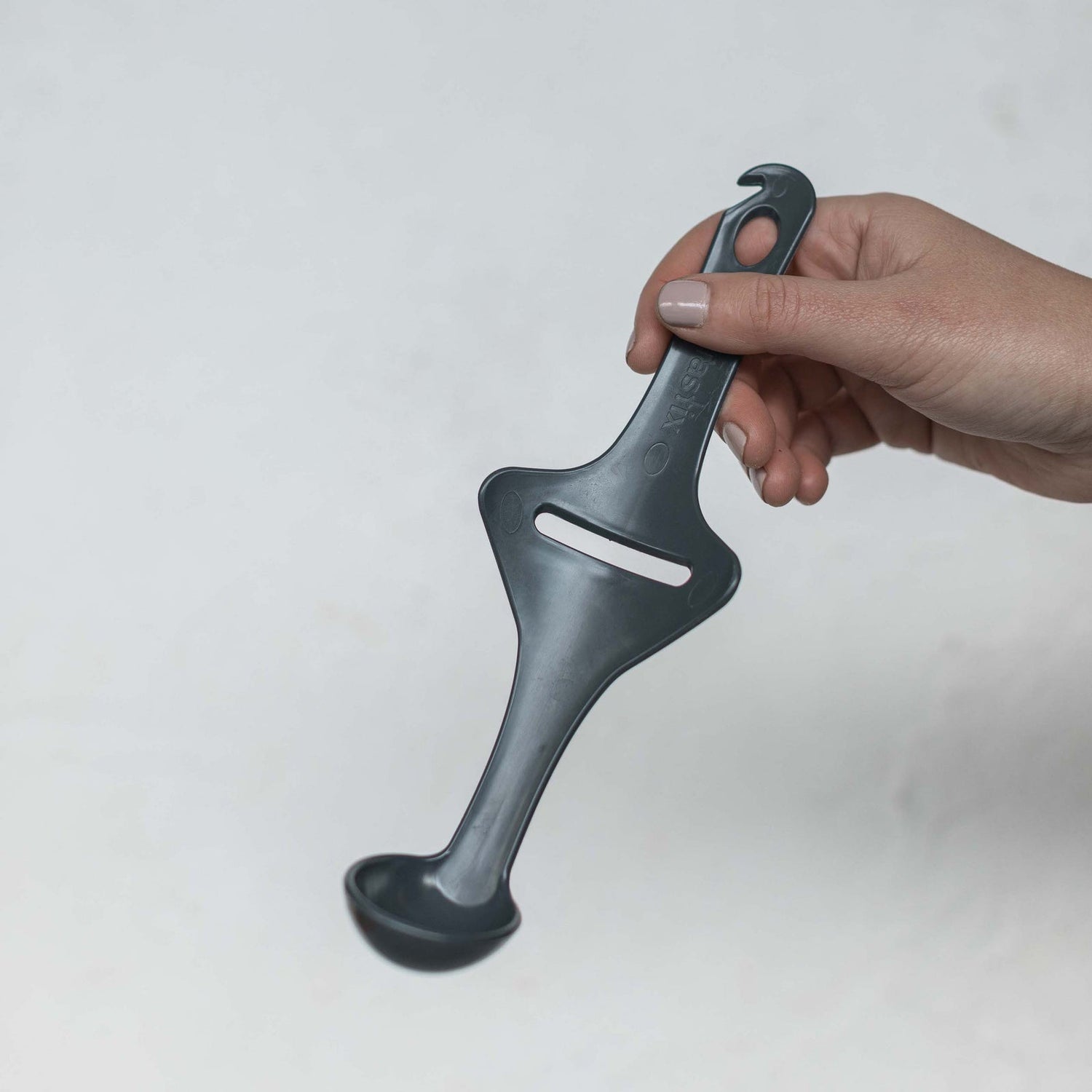 Hand holding the Tastix tasting spoon, a long slim spoon for the Thermomix