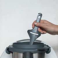 Tastix tasting spoon lowered into the Thermomix mixing bowl through the lid opening