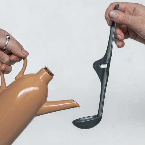 Tastix tasting spoon held beside a ceramic jug