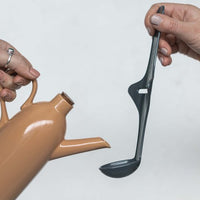 Tastix tasting spoon held beside a ceramic jug