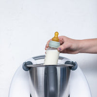Thermo Baby Bottle Warmer being lowered into a Thermomix mixing bowl