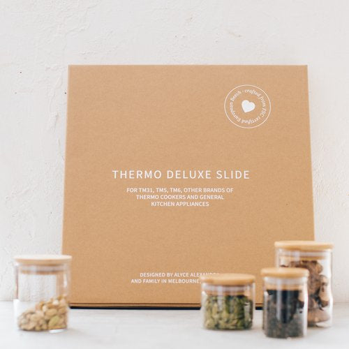 Thermo Deluxe Slide Board in its kraft gift box with storage jars alongside