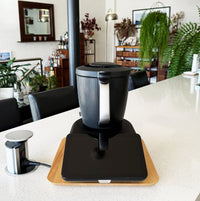 Dark Thermomix on a black Thermo Deluxe Slide Board in a kitchen