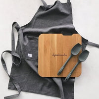 Thermo Deluxe Slide Board on a charcoal apron with matching serving spoons