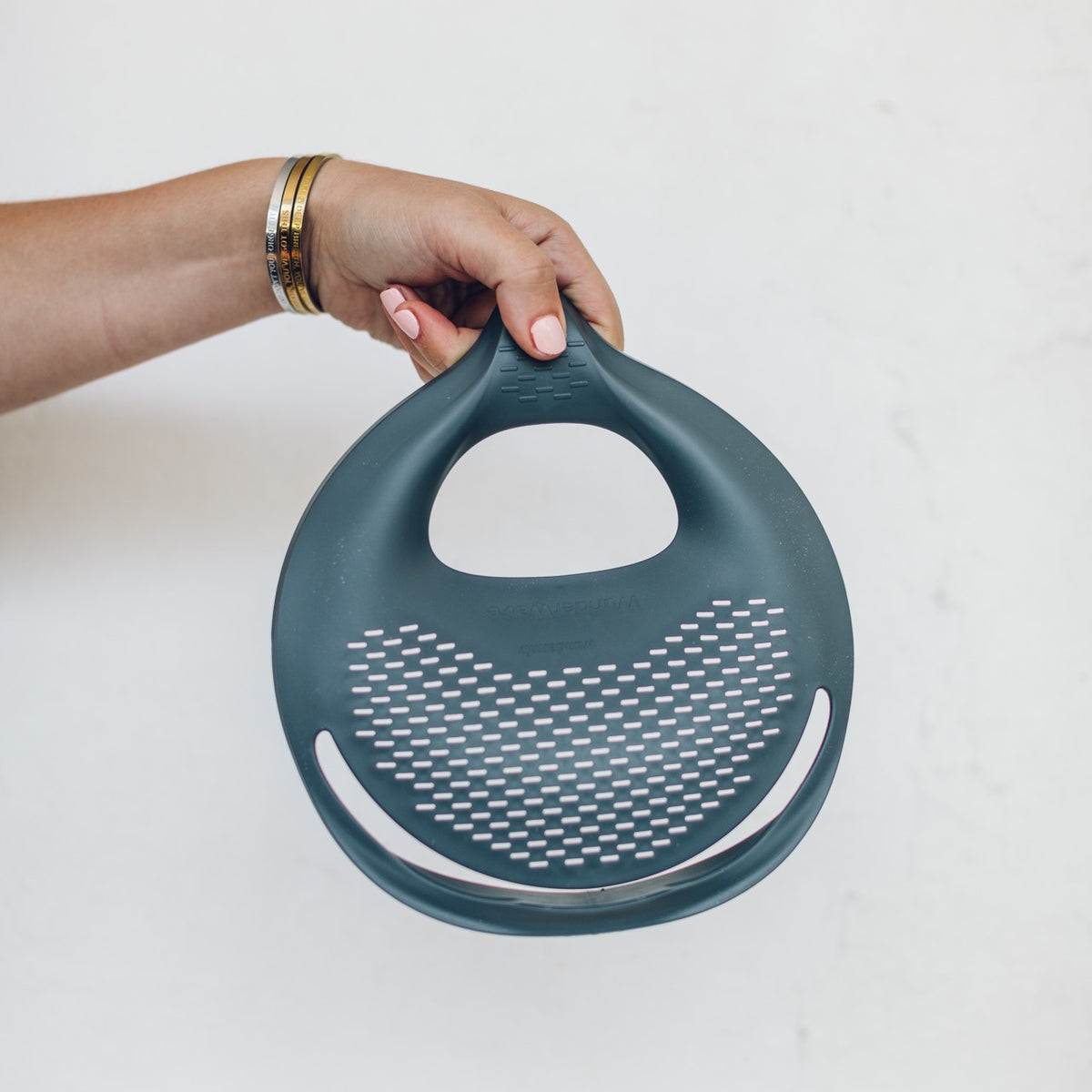 Hand holding the Thermomix bowl with the Thermo Lid Strainer in place
