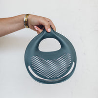 Hand holding the Thermomix bowl with the Thermo Lid Strainer in place