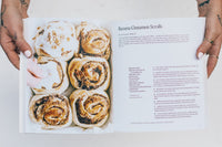 Thermo Plant-Based open at the Basic Cinnamon Scroll recipe beside a tray of scrolls