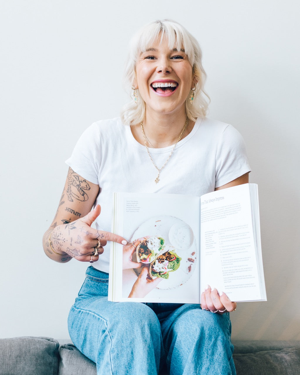 Woman laughing while holding Thermo Plant-Based open at a recipe