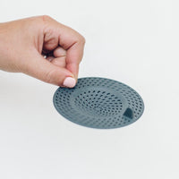 Hand holding the Thermo Splash Cap flat, showing its perforated surface