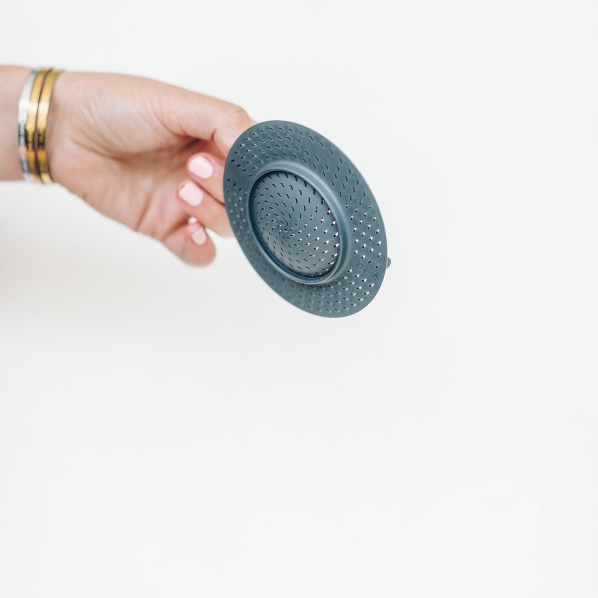 Hand holding the Thermo Splash Cap upright to show its shallow domed shape