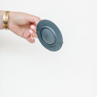 Hand holding the Thermo Splash Cap upright to show its shallow domed shape