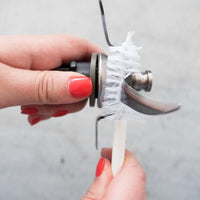 Hand using the TM Blade Brush to clean around the base of the Thermomix blade assembly