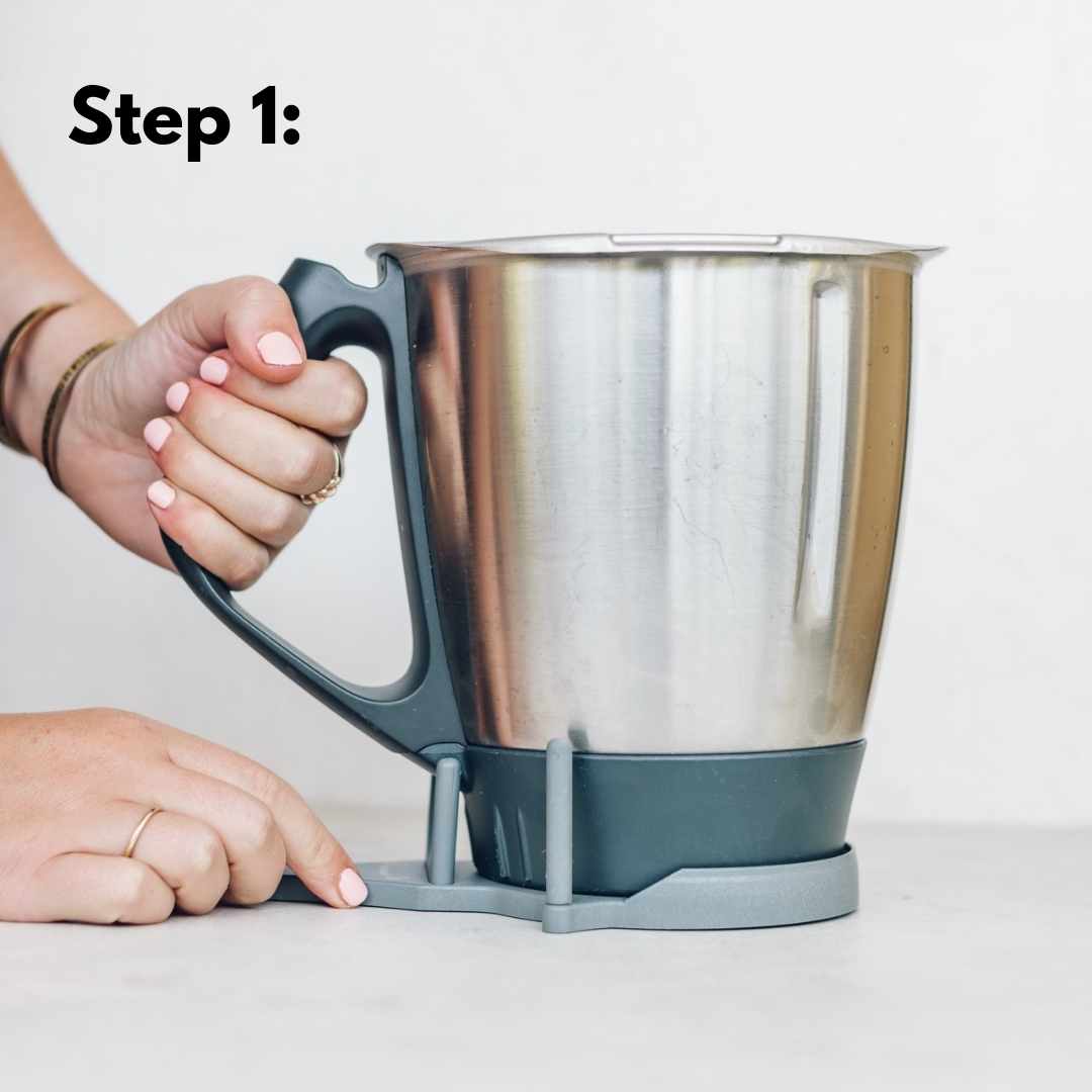 Step 1 of using the TM Twister: hold the Thermomix bowl steady with the twister seated on the base