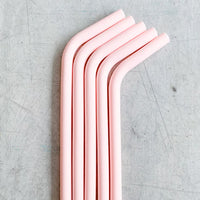 Four pink Wide Reusable Silicone Straws lined up side by side