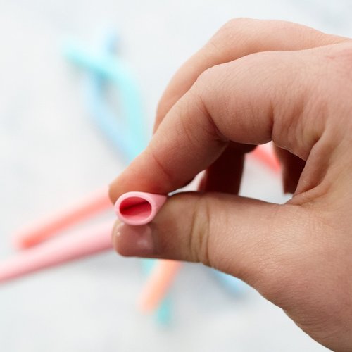 Hand holding a pink Wide Reusable Silicone Straw to show its wide bore
