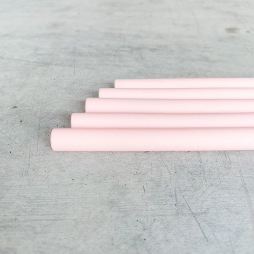 Four pink Wide Reusable Silicone Straws laid in a stepped row