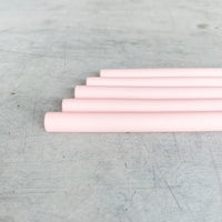 Four pink Wide Reusable Silicone Straws laid in a stepped row