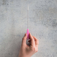 Hand holding a single pink Wide Reusable Silicone Straw