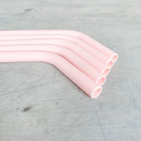 Close-up of a bent pink Wide Reusable Silicone Straw showing its flexible curve